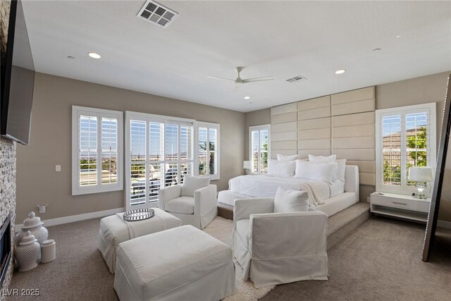 carpeted bedroom with visible vents, a fireplace, baseboards, ceiling fan, and recessed lighting