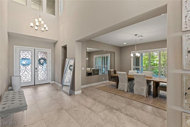 foyer entrance with french doors, baseboards, and a chandelier