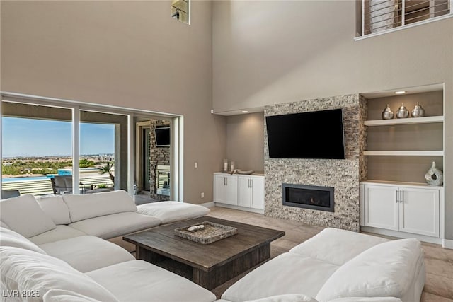 2 Olympia Outlook Dr, Las Vegas, NV 89141 - living room featuring a stone fireplace, a high ceiling, and built in features