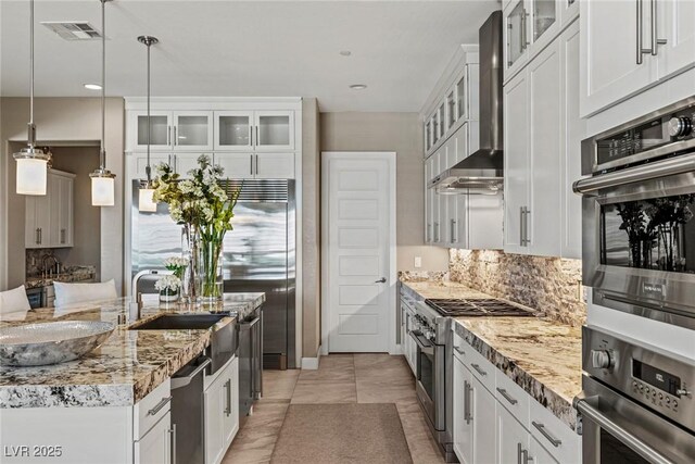 kitchen with white cabinets, stainless steel appliances, and wall chimney exhaust hood
