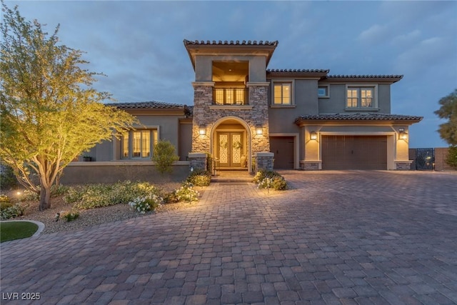 2 Olympia Outlook Dr, Las Vegas, NV 89141 - mediterranean / spanish home featuring stucco siding, a garage, stone siding, decorative driveway, and a tile roof