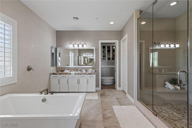 bathroom featuring vanity, a healthy amount of sunlight, and a shower stall