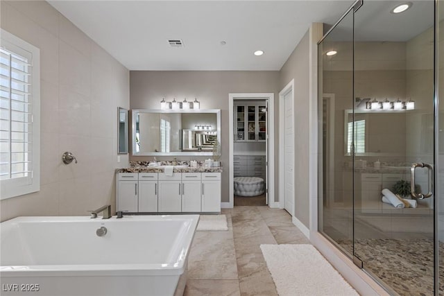 2 Olympia Outlook Dr, Las Vegas, NV 89141 - bathroom featuring double vanity, a soaking tub, a shower stall, healthy amount of natural light, and recessed lighting