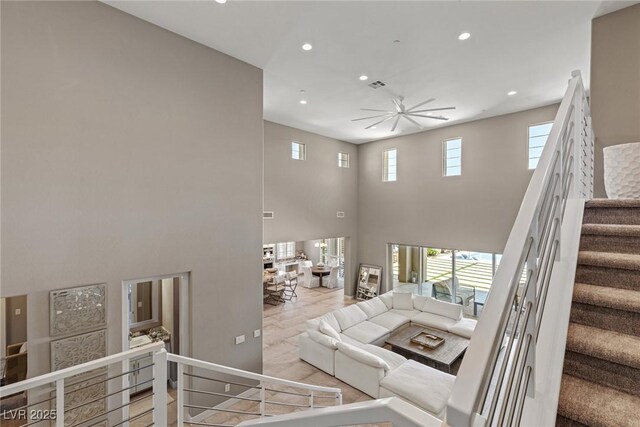 staircase featuring recessed lighting, a high ceiling, visible vents, and a ceiling fan
