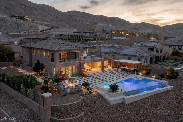 view of pool featuring a fenced in pool, a mountain view, a fenced backyard, and a patio area