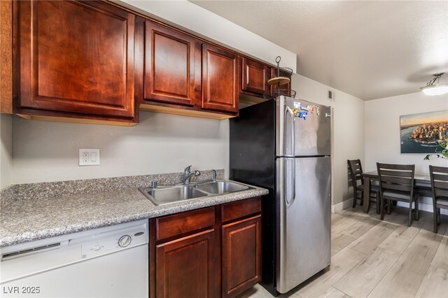 5020 Indian River Dr Unit 424, Las Vegas, NV 89103 - kitchen with a sink, light wood-style floors, light countertops, dishwasher, and freestanding refrigerator