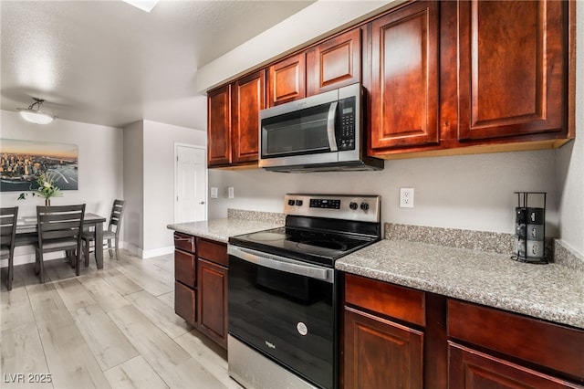 5020 Indian River Dr Unit 424, Las Vegas, NV 89103 - kitchen featuring baseboards, appliances with stainless steel finishes, and light wood-style flooring