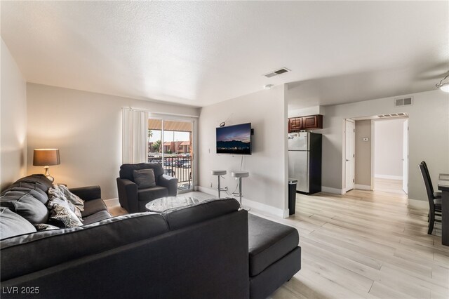 5020 Indian River Dr Unit 424, Las Vegas, NV 89103 - living room with baseboards, light wood-type flooring, and visible vents