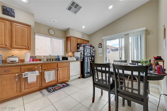 kitchen with a sink, white appliances, recessed lighting, vaulted ceiling, and visible vents