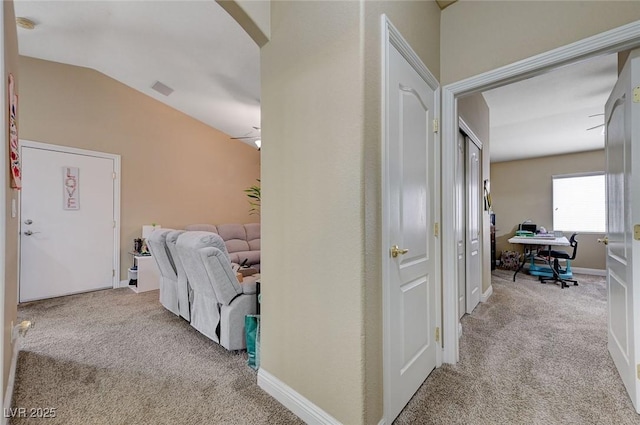 hall featuring carpet flooring, arched walkways, and vaulted ceiling
