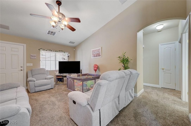 carpeted living area featuring arched walkways, a ceiling fan, visible vents, and lofted ceiling