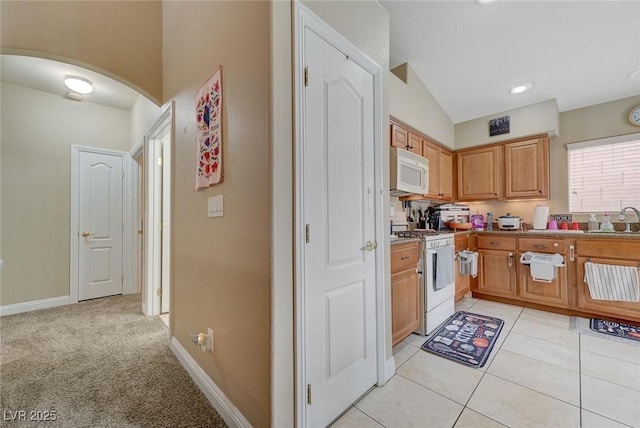 kitchen with baseboards, arched walkways, a sink, and white appliances