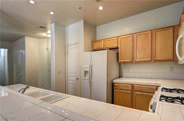 kitchen with visible vents, white appliances, tile counters, recessed lighting, and a sink