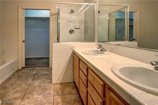 bathroom with a sink, a shower stall, double vanity, and a spacious closet