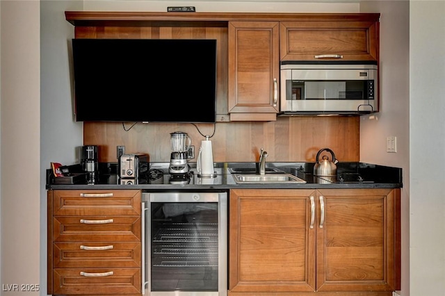 bar with a sink, indoor wet bar, stainless steel microwave, wine cooler, and backsplash