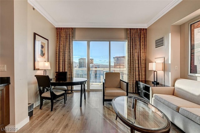 interior space featuring crown molding, baseboards, visible vents, and light wood finished floors