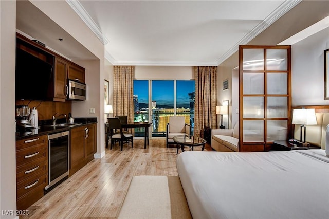 bedroom featuring light wood-style floors, a sink, wine cooler, and crown molding