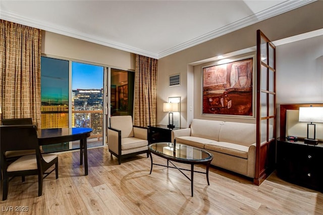 living area with ornamental molding and light wood-style floors