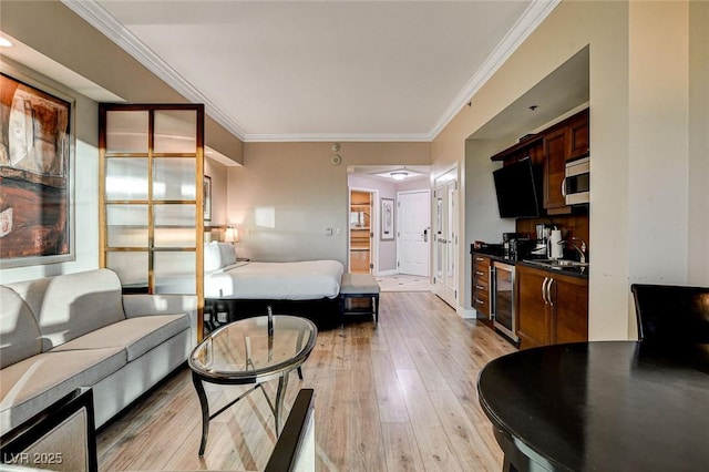 living area with light wood-style floors, crown molding, and beverage cooler