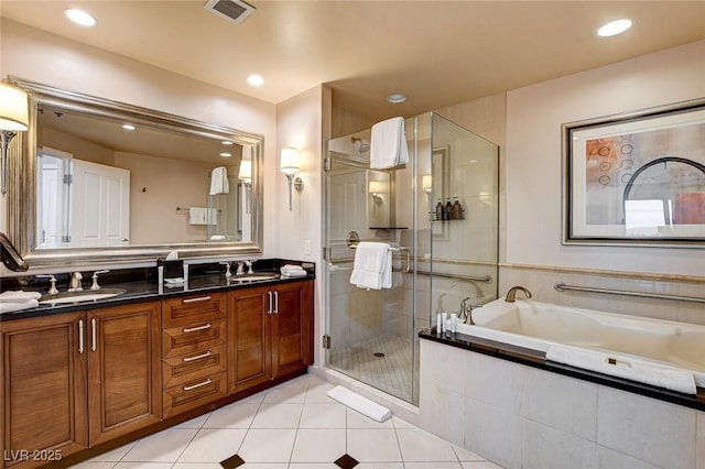 bathroom featuring visible vents, a bath, tile patterned floors, a sink, and a stall shower