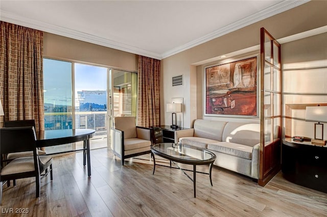 living room with crown molding and light wood-style flooring