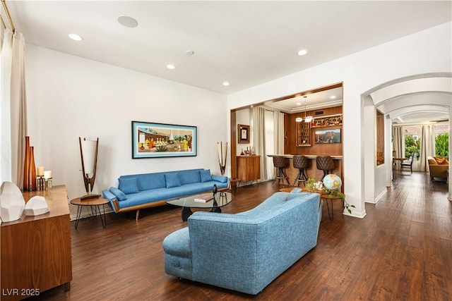 living room with recessed lighting, arched walkways, baseboards, and dark wood-style floors