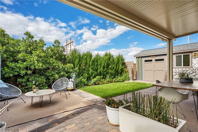 view of patio / terrace featuring outdoor dining space, an outbuilding, and a shed