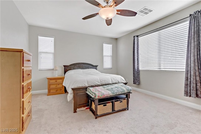 bedroom with visible vents, baseboards, multiple windows, and light colored carpet