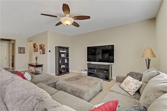 living room with carpet floors, baseboards, and ceiling fan