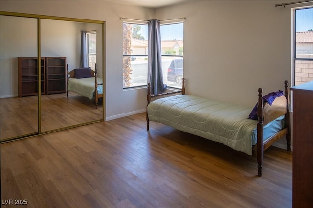 bedroom with baseboards, a closet, and wood finished floors