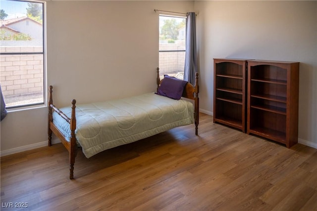 bedroom featuring baseboards and wood finished floors
