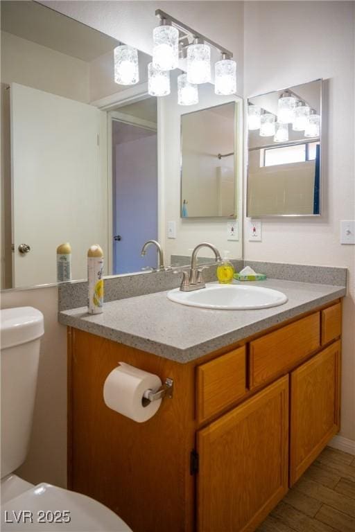 bathroom with vanity, toilet, and wood finished floors