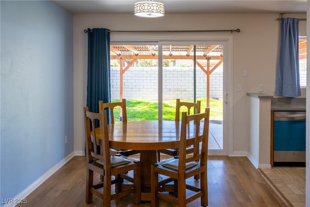 dining area featuring baseboards, plenty of natural light, and wood finished floors