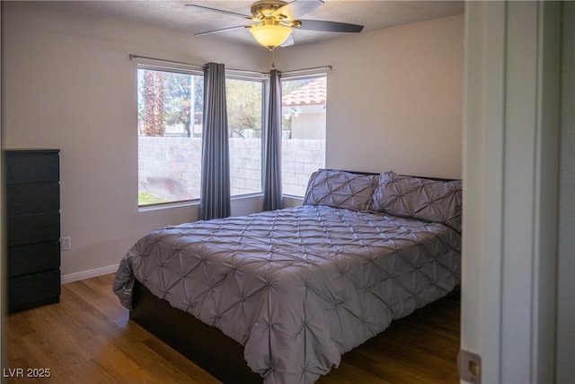 bedroom featuring baseboards, a ceiling fan, and wood finished floors