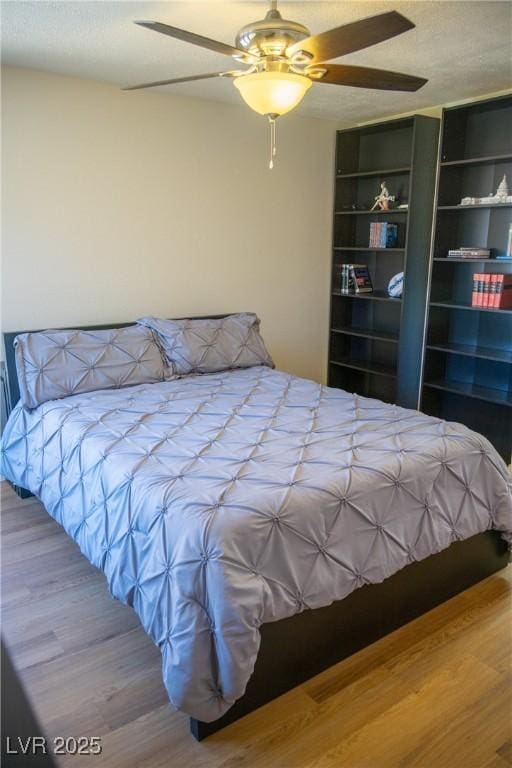 bedroom with ceiling fan and wood finished floors