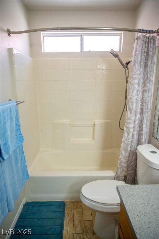 bathroom with vanity, shower / bath combo with shower curtain, and toilet