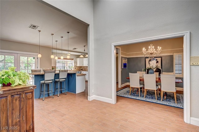 3151 Coachlight Cir, Las Vegas, NV 89117 - dining space featuring an inviting chandelier, baseboards, light wood-style floors, and visible vents