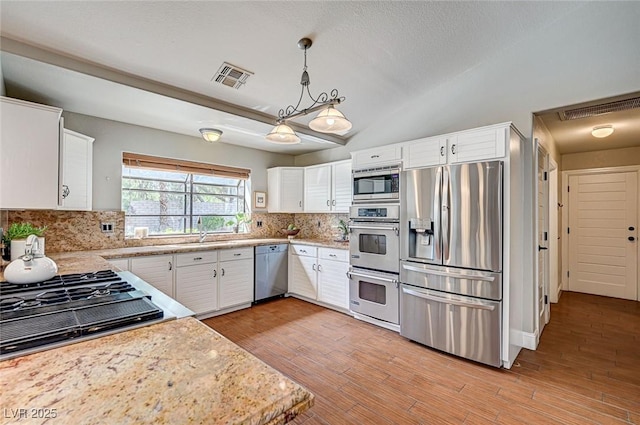 3151 Coachlight Cir, Las Vegas, NV 89117 - kitchen featuring backsplash, stainless steel appliances, visible vents, and white cabinetry