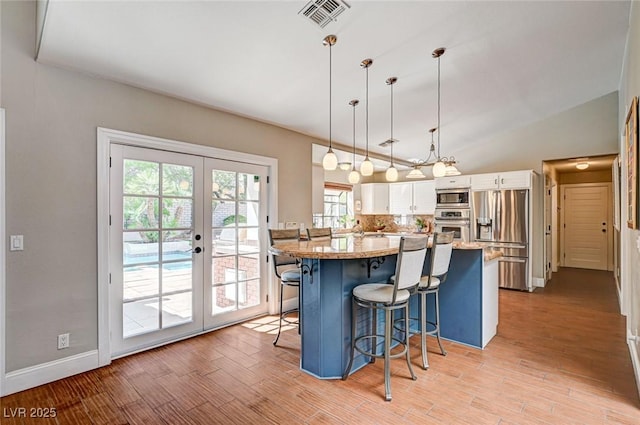 3151 Coachlight Cir, Las Vegas, NV 89117 - kitchen featuring visible vents, a breakfast bar area, white cabinets, french doors, and stainless steel appliances