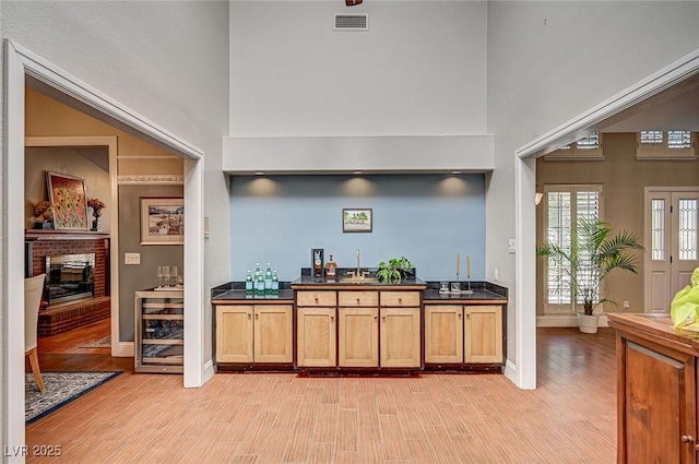 3151 Coachlight Cir, Las Vegas, NV 89117 - bar featuring light wood-type flooring, a sink, wet bar, and baseboards