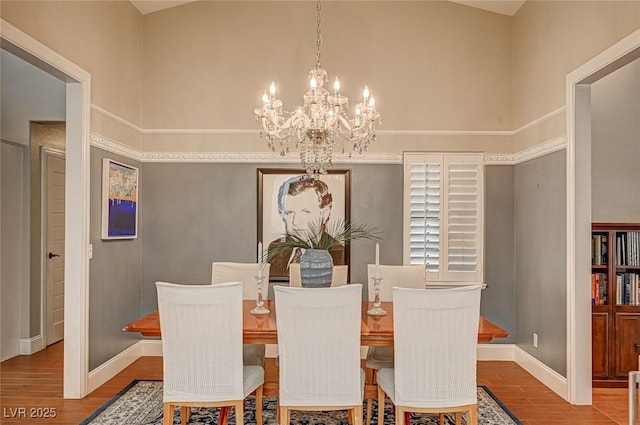 3151 Coachlight Cir, Las Vegas, NV 89117 - dining area with baseboards, wood finished floors, and a chandelier