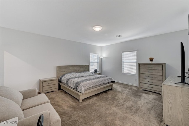 carpeted bedroom featuring baseboards and visible vents