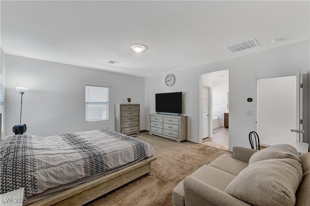 bedroom with visible vents, connected bathroom, and light colored carpet