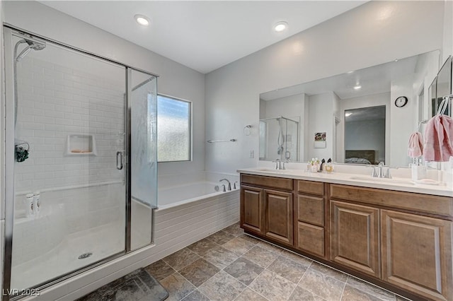 bathroom featuring double vanity, a stall shower, a sink, and a bath