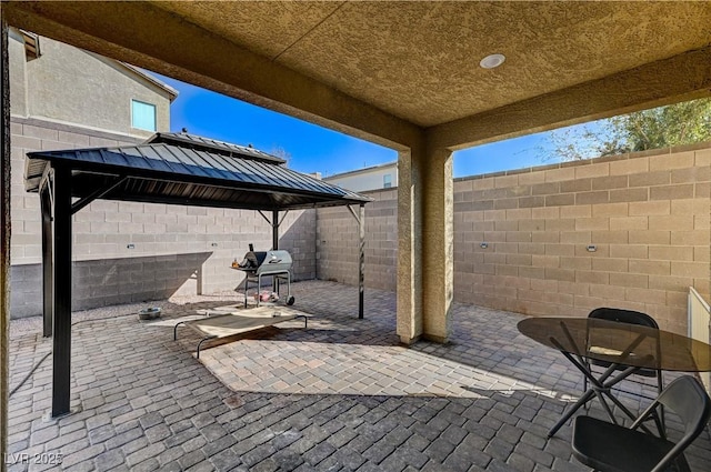 view of patio / terrace featuring a gazebo, a fenced backyard, and grilling area