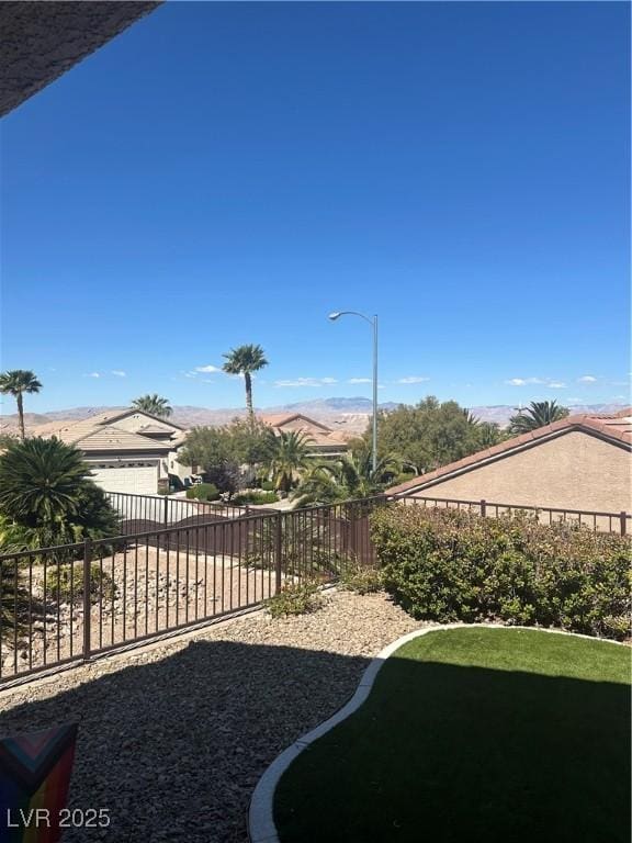 view of yard with a garage, a fenced backyard, and driveway