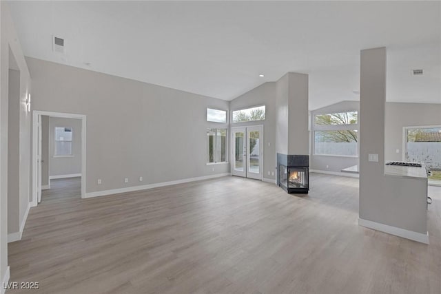 unfurnished living room with baseboards, plenty of natural light, visible vents, and light wood-type flooring