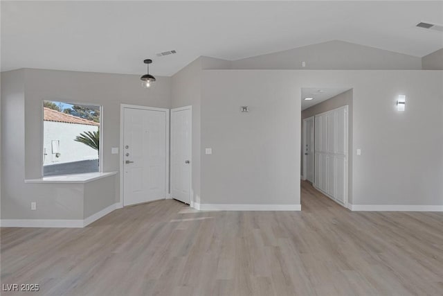 foyer featuring visible vents, light wood-style flooring, and lofted ceiling