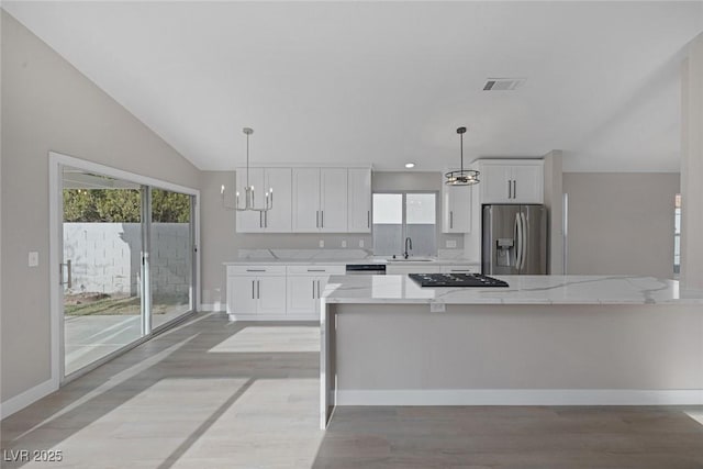 kitchen featuring stainless steel fridge, a chandelier, white cabinets, and black gas cooktop