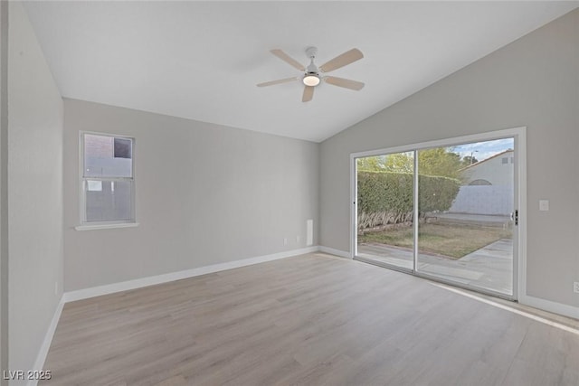 empty room featuring wood finished floors, baseboards, ceiling fan, and lofted ceiling